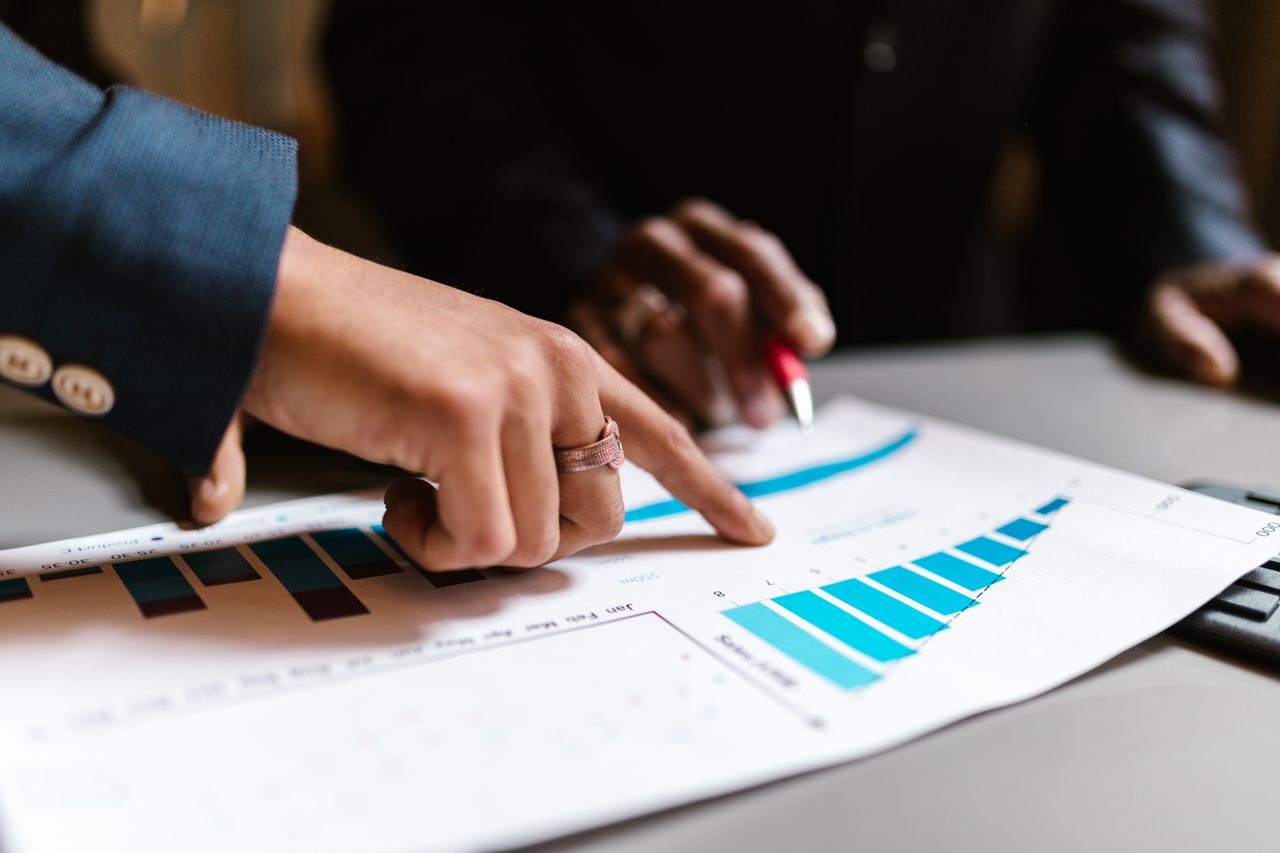 our-story Close-up of hands analyzing financial charts during a business meeting.